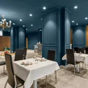 Hotel Regina Caserta · 4 stelle · A due passi dalla Reggia Sala da pranzo elegante con pareti blu e tavoli apparecchiati con tovaglie bianche
