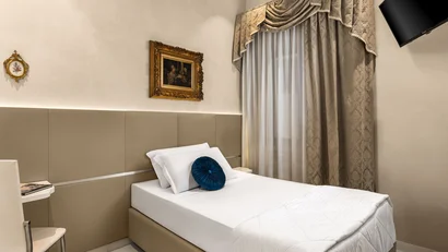Hotel Regina Caserta · 4 stelle · A due passi dalla Reggia Camera singola elegante con letto bianco e tenda decorativa beige