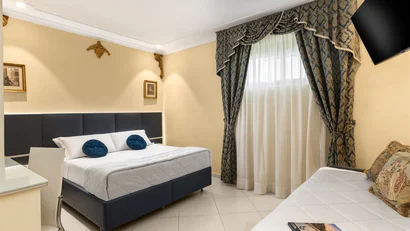 Hotel Regina Caserta · 4 stelle · A due passi dalla Reggia Camera d'albergo con letto matrimoniale, divano, tende ornate e TV a parete