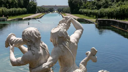 Hotel Regina Caserta · 4 stelle · A due passi dalla Reggia Statua di due figure mitologiche vicino a un lungo canale d'acqua in un giardino