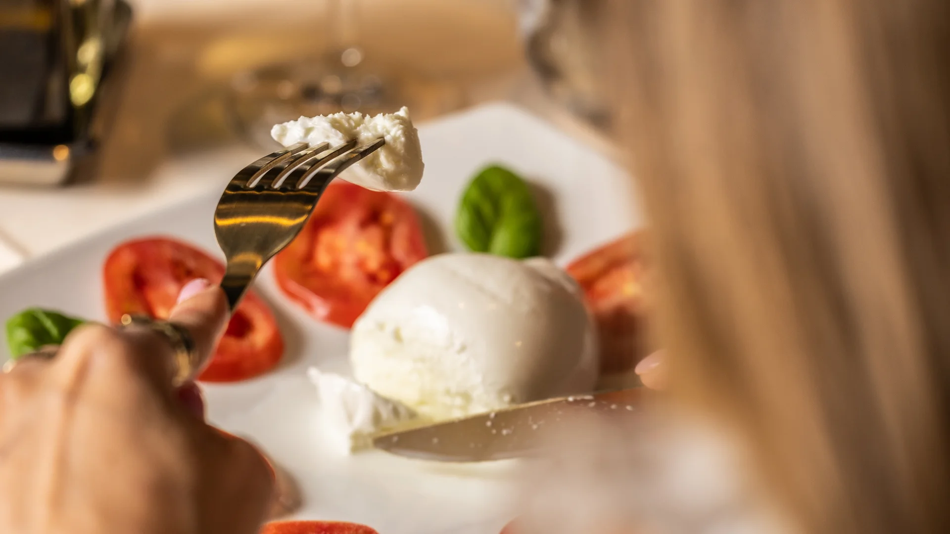 Hotel vicino alla Reggia di Caserta · Regina 4★ Donna che mangia insalata caprese con mozzarella, pomodori e basilico