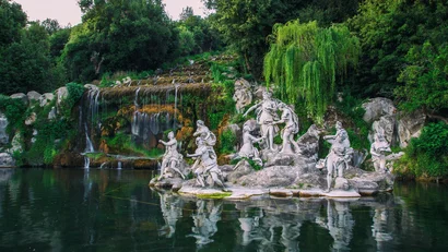 Hotel Regina Caserta · 4 stelle · A due passi dalla Reggia Statue di figure mitologiche vicino a una cascata in un giardino verde
