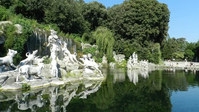 Hotel Regina Caserta · 4 stelle · A due passi dalla Reggia Statue di cani e figure umane vicino a una cascata e un lago con riflessi