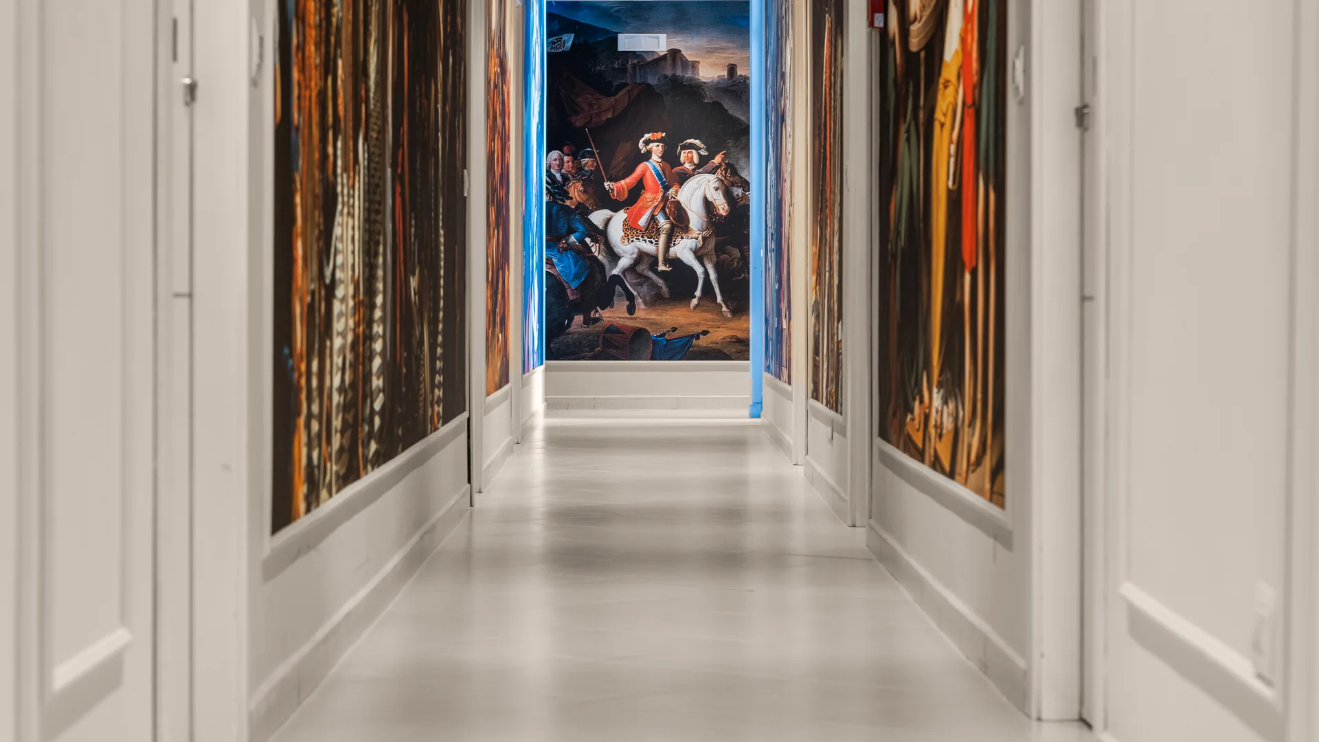 Hotel vicino alla Reggia di Caserta · Regina 4★ Corridoio con pareti decorate da grandi dipinti storici e quadro di uomo a cavallo