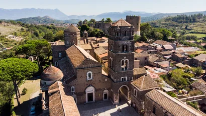 Hotel Regina Caserta · 4 stelle · A due passi dalla Reggia Veduta aerea di un antico complesso di edifici storici con torri e tetti in terracotta
