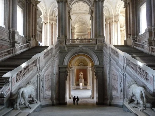 Hotel vicino alla Reggia di Caserta · Regina 4★ Interno di un grande palazzo con due scale simmetriche e statue di leoni in marmo