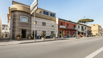 Hotel Regina Caserta · 4 stelle · A due passi dalla Reggia Facciata moderna di un hotel con piante in vaso lungo la strada