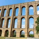 Hotel Regina Caserta · 4 stelle · A due passi dalla Reggia Antico acquedotto in pietra con archi sotto un cielo azzurro
