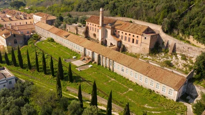 Hotel Regina Caserta · 4 stelle · A due passi dalla Reggia Veduta aerea di un edificio storico con tetti in tegole e alberi cipressi