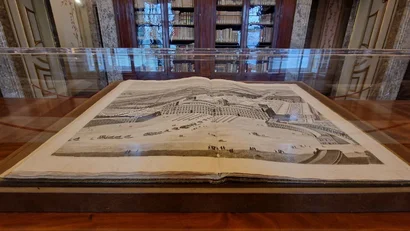 Hotel Regina Caserta · 4 stelle · A due passi dalla Reggia Libro antico aperto con illustrazione di un palazzo storico in una teca di vetro