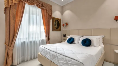 Hotel Regina Caserta · 4 stelle · A due passi dalla Reggia Camera da letto elegante con letto matrimoniale e tende arancioni